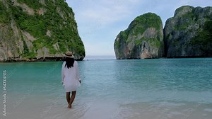 Koh Phi Phi Thailand, Asian Thai women with hat walking at the beach of Maya Bay on a empty beach in the morning
