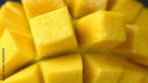 Rotation close-up of rip mango slice cubes cut in 4K resolution