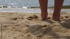 Slender young woman takes off her bikini and goes to swim in the sea