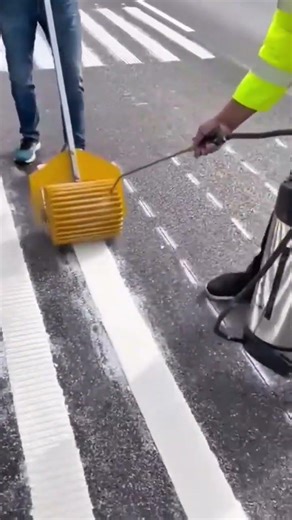 applying white reflective paint to create structured road markings with specialized rolling machine