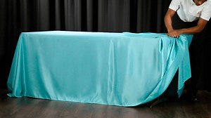 Unsure how to style a rectangular tablecloth? Drape tying it will keep those pesky corners tucked away while giving you a tidy look! | CV Linens