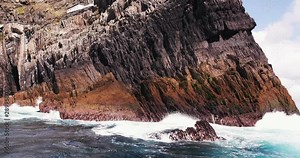 Waves crashing on rocks sailing round The Island Skellig Michael In Ireland