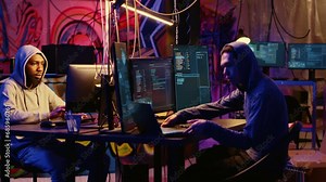 Beginner hacker requesting help from experienced cybercriminal, learning how to destroy firewalls and infect victim computer. Cracker in secret hideout teaches script kiddie how to write malware code