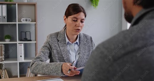 Interview recruitment in office manager meets candidate. HR manager checks documents, noting experience and fit, and discusses eligibility with applicant job seeker. Hiring and employee recruit.