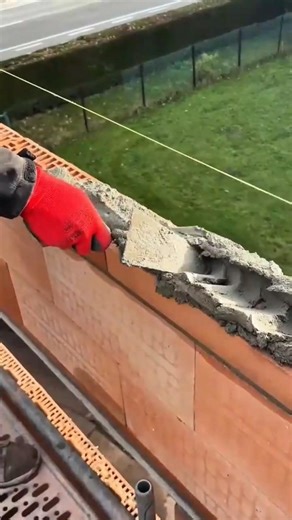 The process of laying bricks with cement using tools to create a strong and neat structure