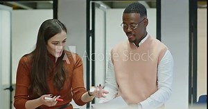 Multigenerational colleagues work together towards a project deadline, combining efforts in analyzing reports and deliberating on strategies to drive business growth.