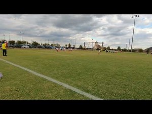High kick in the goalie box. Blond boy orange team