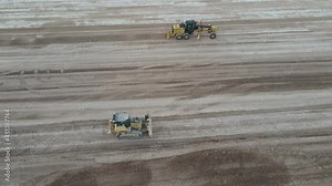 Bulldozer and scraper tractors working side by side in a landfill. 4k drone footage