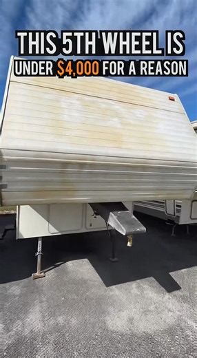 used 26-foot 5th wheel listed for $3,990. The footage focuses only on the trailer itself, with no people shown. The exterior condition explains the low price at first glance, with faded paint and sun-worn surfaces on the front cap. A closer look reveals more important details. The roof line remains straight, slide seals appear intact, and the flooring near the entry is solid. No visible water staining is present on interior surfaces. These structural factors significantly reduce risk when evalua