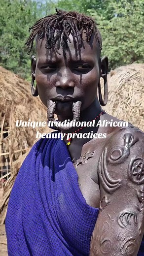 The Mursi tribe in southwestern Ethiopia is known for its distinctive lip plate tradition. Women begin the practice around puberty by cutting the lower lip and inserting a small wooden peg, gradually using larger plates to stretch the lip. This tradition, which likely originated as a deterrent against slave traders, has become a significant cultural symbol. The lip plates signify beauty, social status, and readiness for marriage, with larger plates often associated with higher bride prices. This