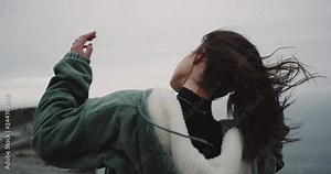 In amazing place of Cliffs of Moher , woman standing on the shore of Cliffs and have meditation time , on a windy day. 4k
