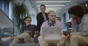 A diverse group of colleagues exchange business experiences, engage in collaborative problem-solving, and work together in a relaxed, modern office interior, demonstrating the value of teamwork and