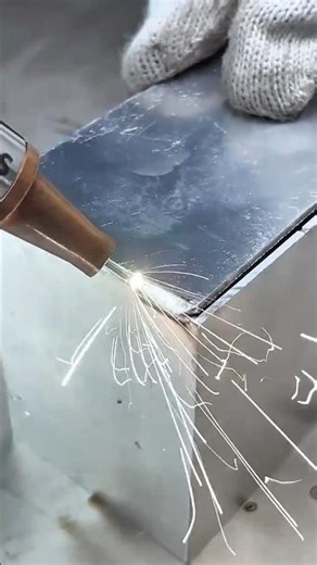 welding the edges of two pieces of shiny metal together using a professional handheld welding torch
