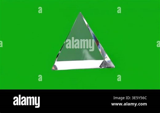 A clear glass pyramid rotates slowly on a solid green screen background, showcasing its geometric shape and light refractions Stock Video Footage - Alamy
