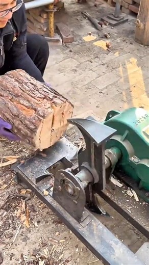 splitting a round wood log precisely using a heavy automatic mechanical wood splitter
