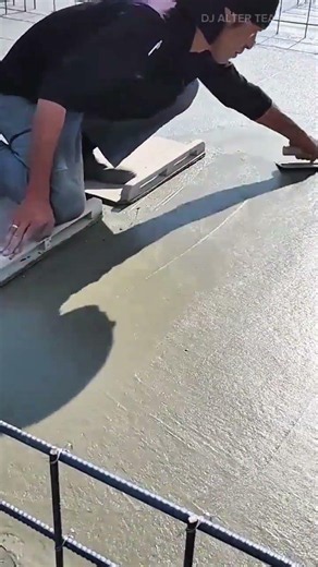 smoothing the wet concrete surface using a hand trowel to ensure the floor becomes perfectly flat
