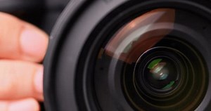 Photographer taking photo with flash in studio.