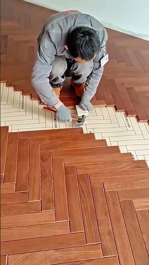 Professional installation of a herringbone wood floor pattern