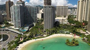 Cinematic 4K aerial drone rising shot of high-rise hotels on the shore of Waikiki, vibrant, popular tourist destination near Honolulu on Oahu island in Hawaii known for its popular surf beach