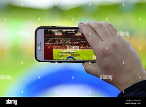 Munich, Germany. 13th Mar, 2019. Soccer: Champions League, knockout round, round of sixteen, second leg: FC Bayern Munich - FC Liverpool in the Allianz Arena. A fan uses his smartphone to record a video of the teams on the pitch. Credit: Matthias Balk/dpa/Alamy Live News Stock Photo - Alamy