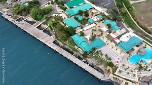 La Romana, Dominican Republic, flying backwards from La Romana Cruise Terminal with pier, located at Rio Dulce, with panning up to area overview - 4K aerial video footage