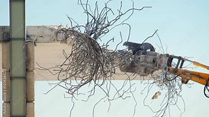 Building demolition using a hydraulic excavator with a demolition and sorting grab. Slow motion.