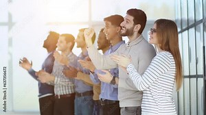 A group of people standing in a row clapping their hands
