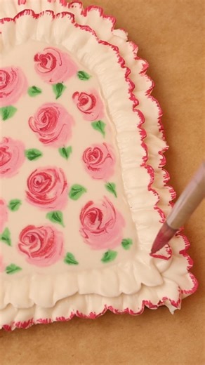 I made these wet-on-wet royal icing cookies after being inspired by a ruffle edge dinner plate by The ARK elements. The roses are painted with edible paint and shaped with a scribe tool. The full tutorial along with my cookie recipes and royal icing recipes are in the Cookie Art Club! #decoratedcookies #royalicing #wetonwet #valentinesdaytreats | SweetAmbs