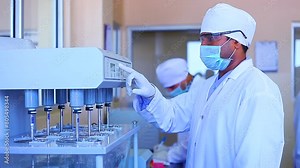 tablet dissolution test apparatus working condition close up. a scientific instrument dissolving tablets in a science instrumentation chemistry laboratory