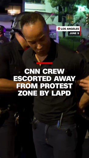 CNN's Jason Carroll and his crew were escorted out of a LA protest zone by police officers. One police officer told the crew to put their hands behind their backs so they could be walked out of the protest zone | CNN