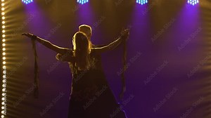 Elements of classical waltz choreography performed by pair of ballroom dancers. Partners man and woman waltz holding hands. Shot in a dark studio against a black background with blue lights. Close up.