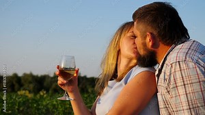 Young couple spending time together at countryside. Happy pair relaxing and kissing at corn field. Husband and wife are have a dating at nature. Concept of loving and happiness. Slow motion