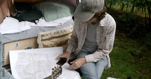 Man explains how to use a map app on a smart phone to his male friend