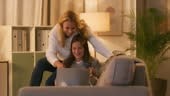 Mother and daughter using laptop and credit card for online shopping...