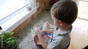 A little boy creating volcano out of paper mache for a science project