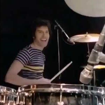 Freddie Mercury playing drums and Roger Taylor playing guitar