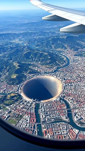 High above Bilbao, Spain, a massive, perfectly circular hole stretches into the ground near the edge of the city. The Basque hills and winding river surround it, the scene still, silent, and impossibly deep. #spain #fblifestyle #coldfront #winterweather #earthimpacts This content isn’t real — it’s a simulated ‘what if’ scenario created by AI for visual exploration. | Earth Impacts