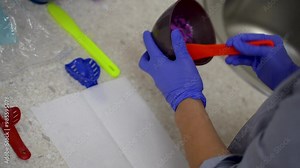 Alginate impression, orthodontist preparing a purple mixture. Dentist mixing dental alginate impression material powder