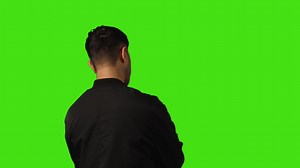 Rear View Of Bored Or Fed Up Young Man Standing And Waiting Against Green Screen Background | Free Stock Video Footage