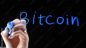 The word bitcoin on a black background. The blue color of the text. The girl's hand draws an arrow on a transparent board. Growth arrow