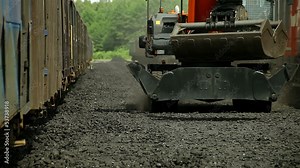 excavators, unloading coal from a cargo train.