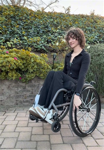 🦜✨🤍 Alt text: a woman comes into frame in her wheelchair from the left and stops in a wheelie, smiles at the camera, leaves to the right and then does it again from the right side. #Wheelie #Random #HeeHee #Funny #Cute