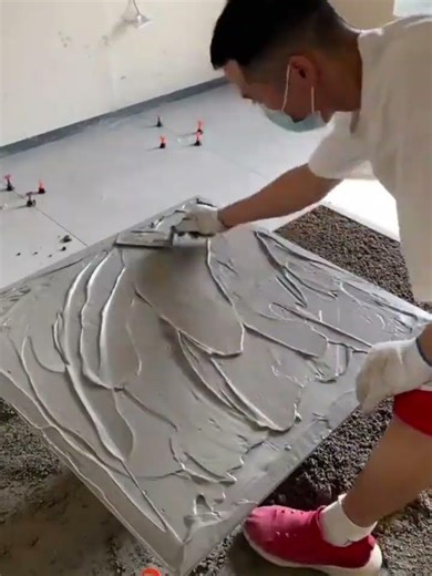 the process of installing ceramic tiles on the floor in a large room in a building #construction