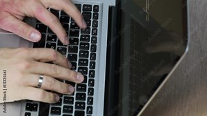 Programming on a macbook laptop, slightly sped up so that more code is visible. Screen shows both computer code and reflection of programmers hands