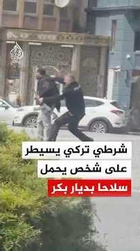 شرطي تركي يسيطر على شخص يحمل سلاحا بديار بكر