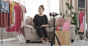 Teenage fashion vlogger recording live video about trendy outfit