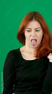 disgust dissatisfied facial expression stick out tongue gagging Reflex woman with red hair distorts her face with a grimace negative emotions smile at the end on a green background person