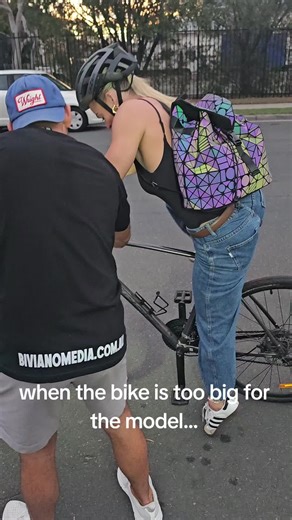 Photoshoot Fail: Model Struggles with Oversized Bike