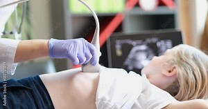 Doctor conducts ultrasound examination of internal organs of child in clinic closeup