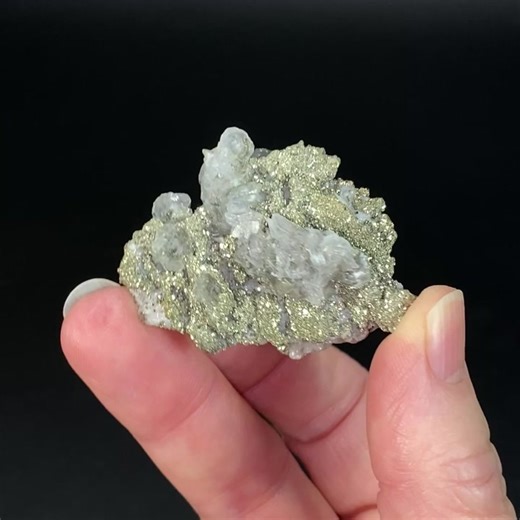 Pyrite after pyrrhotite, with flattened rhombohedral calcite, from Trepca Mine Complex, Mitrovica, Kosovo.Calcite fluorescent with 365nm long wave UV light.Size: 45 x 36 x 35 mm. 32 grams.Pyrite after pyrrhotite pseudomorph is a mineral specimen that shows the replacement of pyrrhotite by pyrite, preserving the original shape and structure of the former. Pyrrhotite is an iron sulfide mineral that often forms hexagonal or pentagonal crystals, sometimes resembling roses. Pyrite is another iron sul